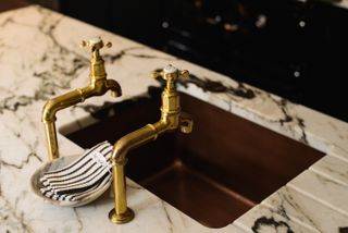 Aged brass faucet and a marble counter top