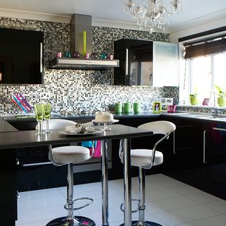 kitchen with black cabinets and mosaic wall tiles