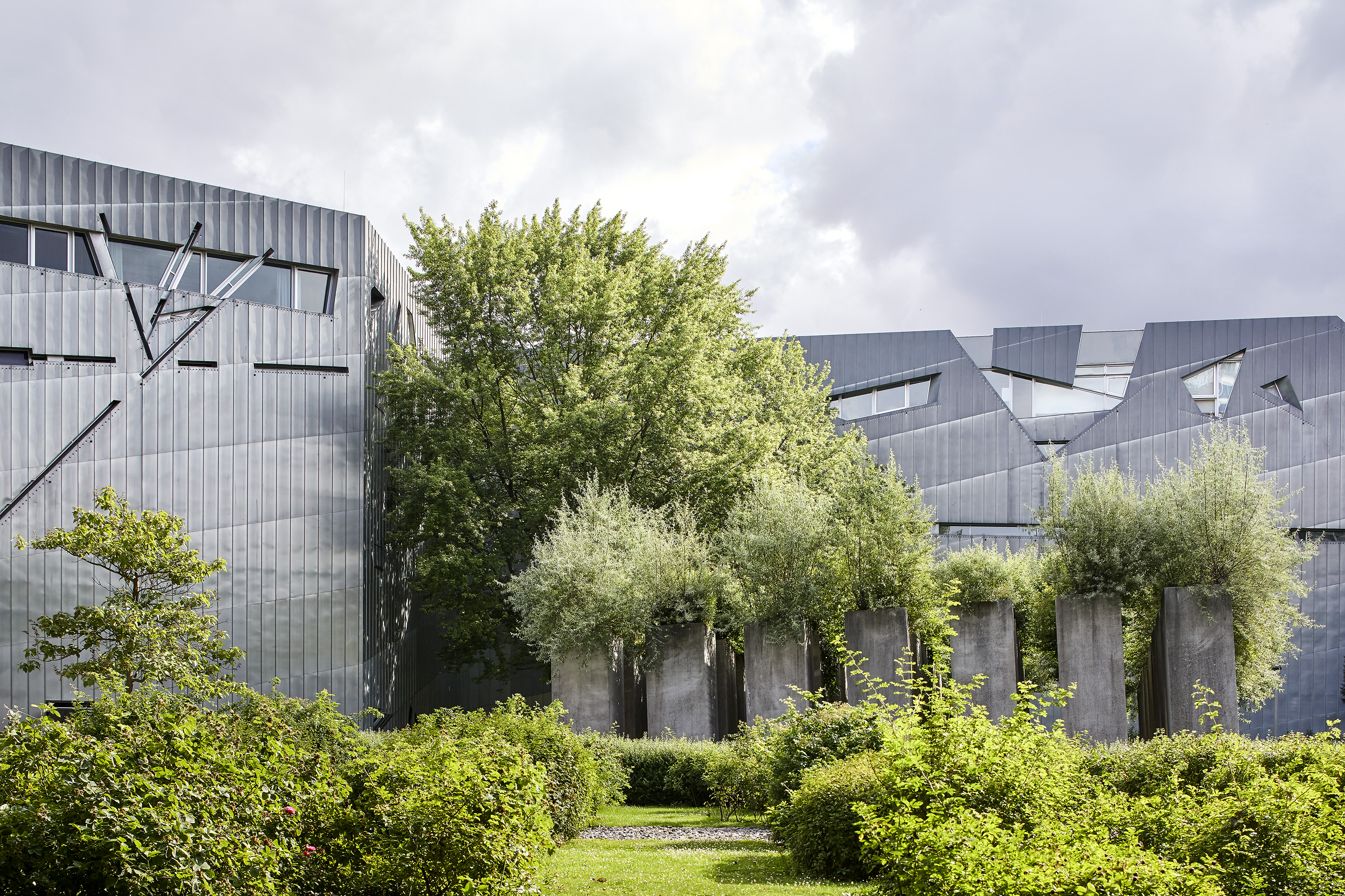 Jewish Museum Berlin by Daniel Libeskind on a sunny day, angular forms under blue sky 