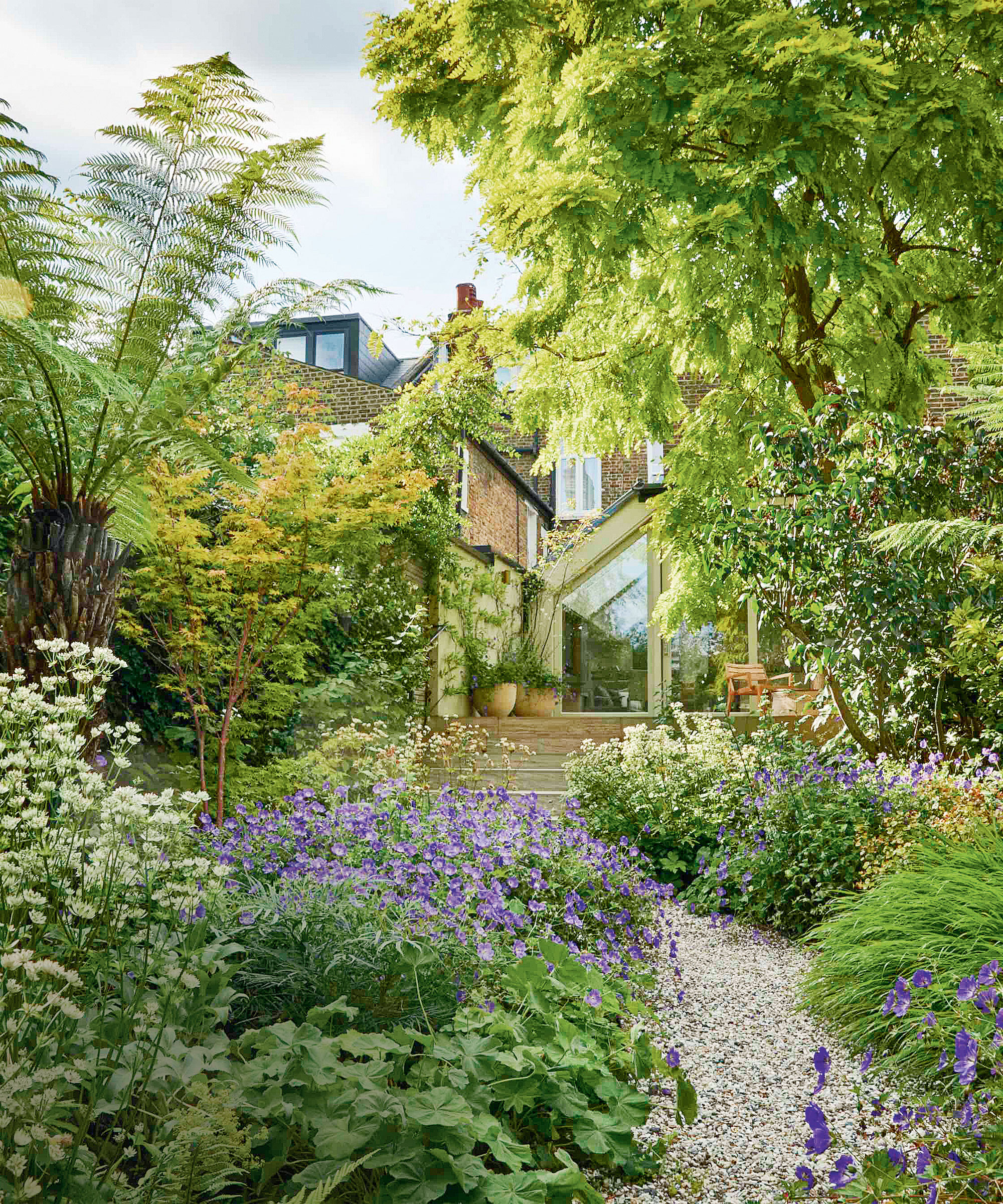 Large green garden with gravel path leading up to house