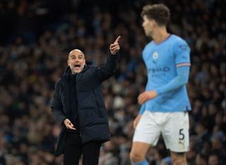 Manchester City manager Pep Guardiola shouts instructions to John Stones during the Premier League match between Manchester City and Tottenham Hotspur at Etihad Stadium on January 19, 2023 in Manchester, United Kingdom.