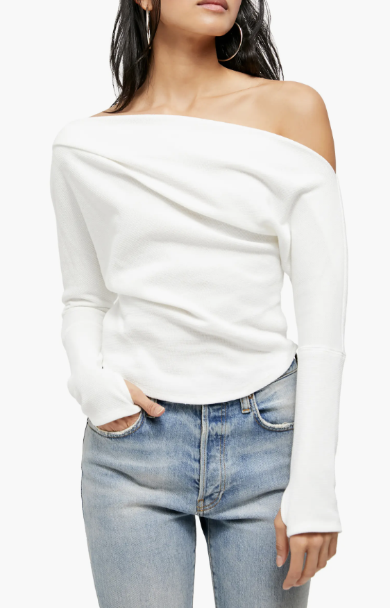 a model wears a white slouchy top inspired by Bella Hadid in front of a plain backdrop