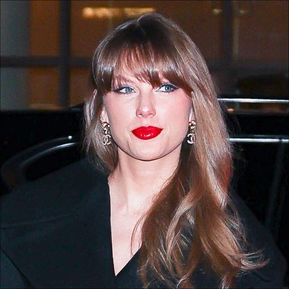 Taylor Swift wearing a black outfit and red lipstick