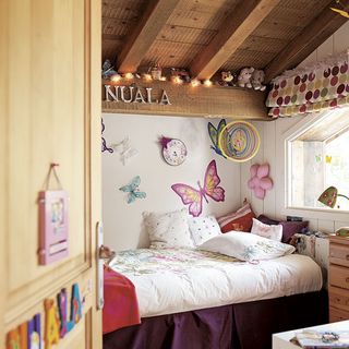 attic bedroom with white wall and butterfly stickers