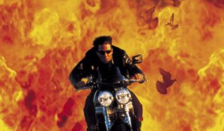 Tom Cruise riding a motorcycle out of flames in Mission: Impossible 2.