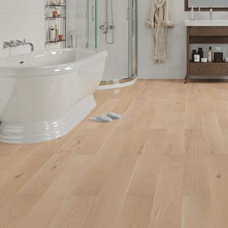 pale wood flooring in bathroom with a white bath and chrome shower enclosure