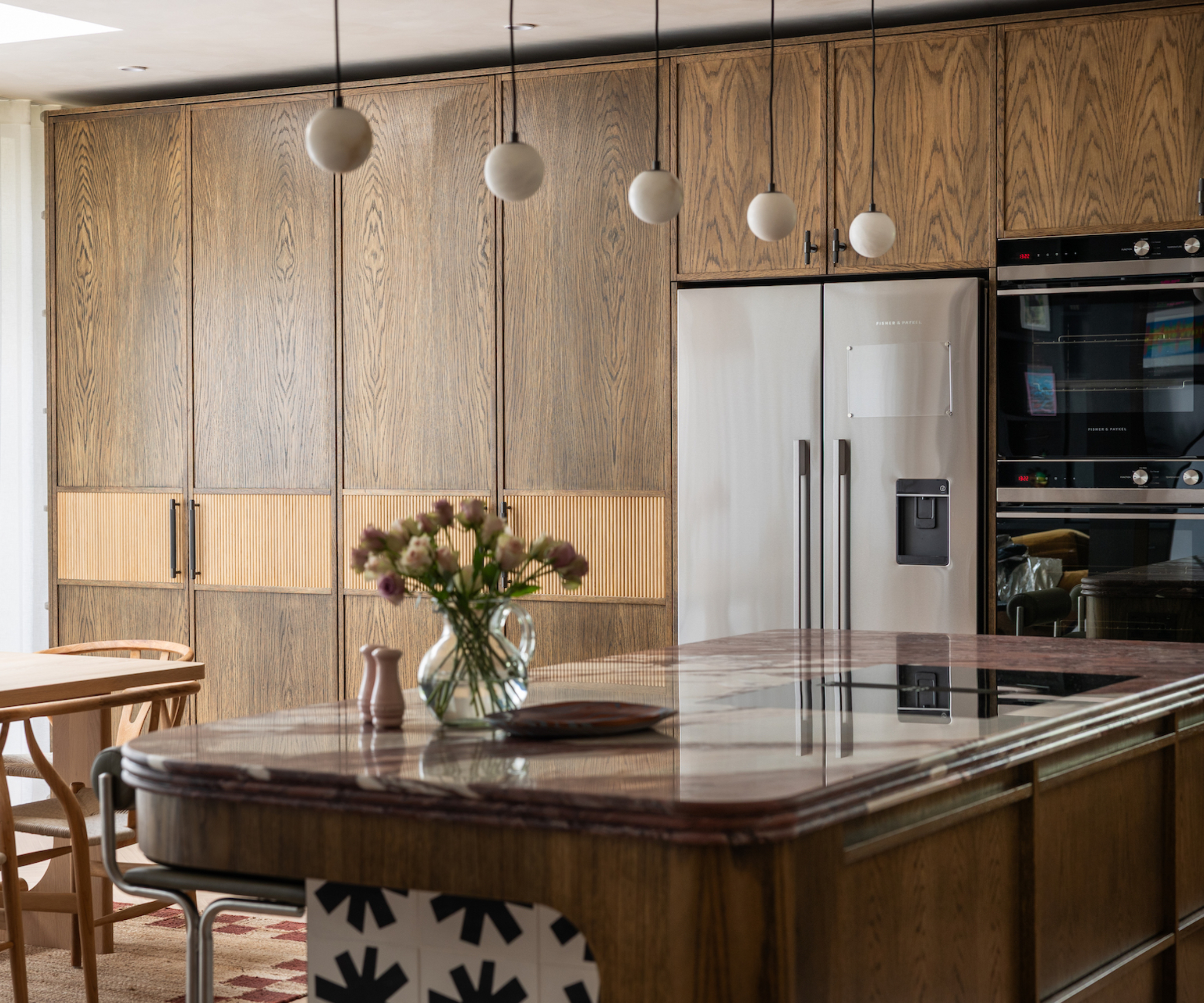 kitchen with wooden cabinets and 5 small spherical pendants hanging above kitchen island