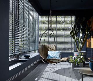 Venetian blinds by Blinds2go in a sunroom with hanging egg chair