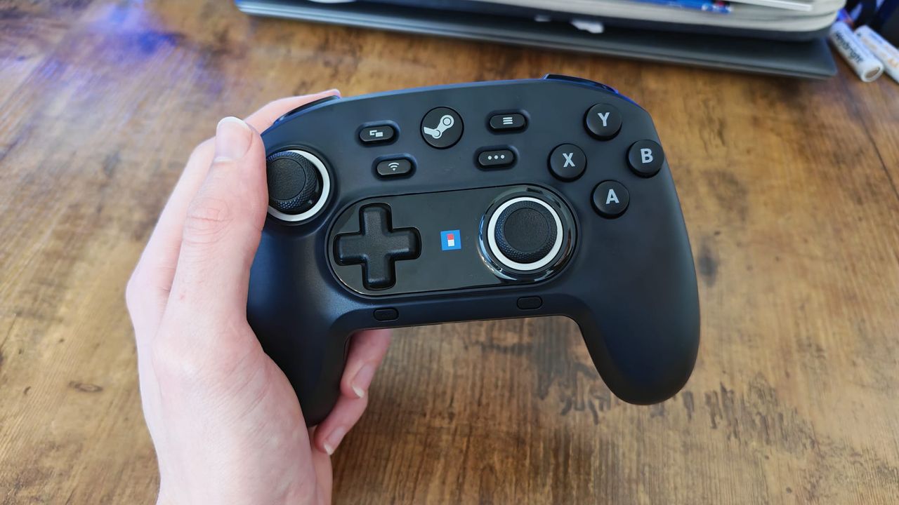 A reviewer holding the Hori Wireless HORIPAD for Steam