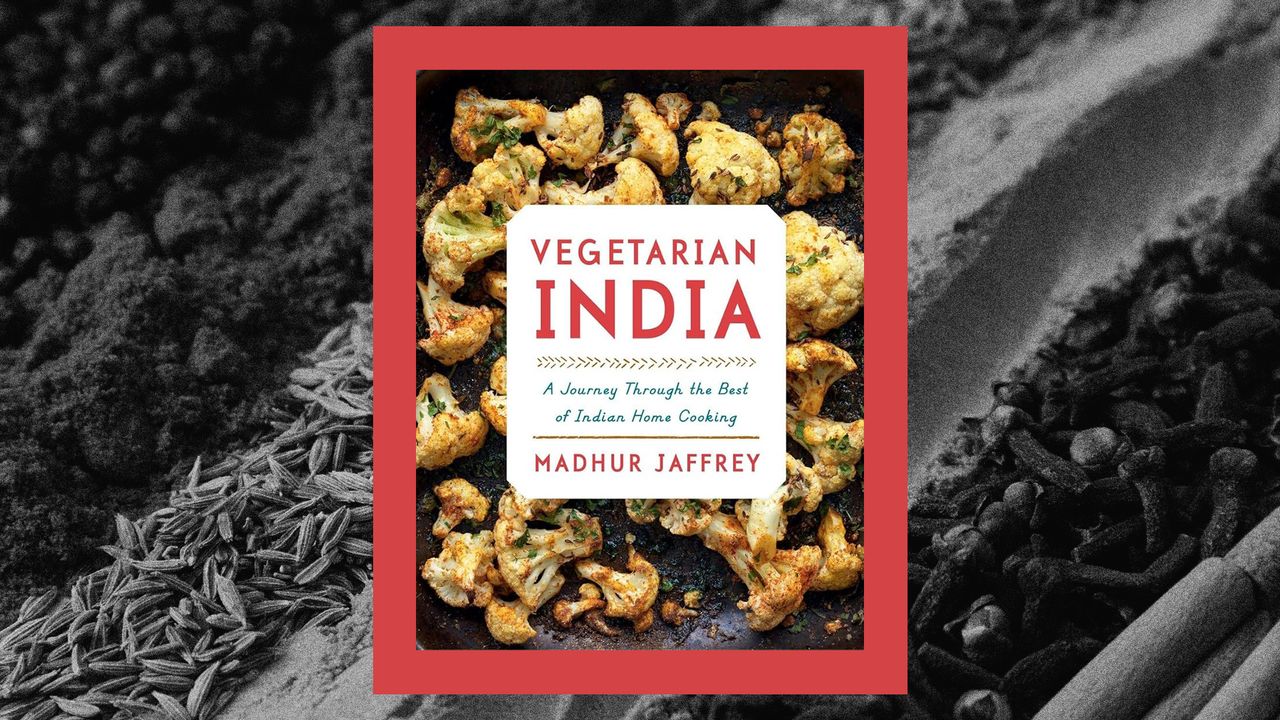 The cover of Madhur Jaffrey&#039;s &#039;Vegetarian India&#039; on a background of close-up photo of spices common to Indian cooking.