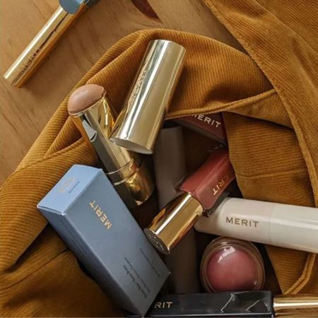 A merit makeup bag filled with products