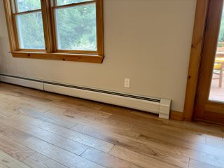 A baseboard heater beneath a window