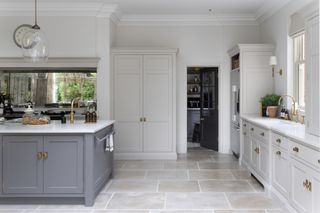 a light grey and dark grey kitchen with stone floors