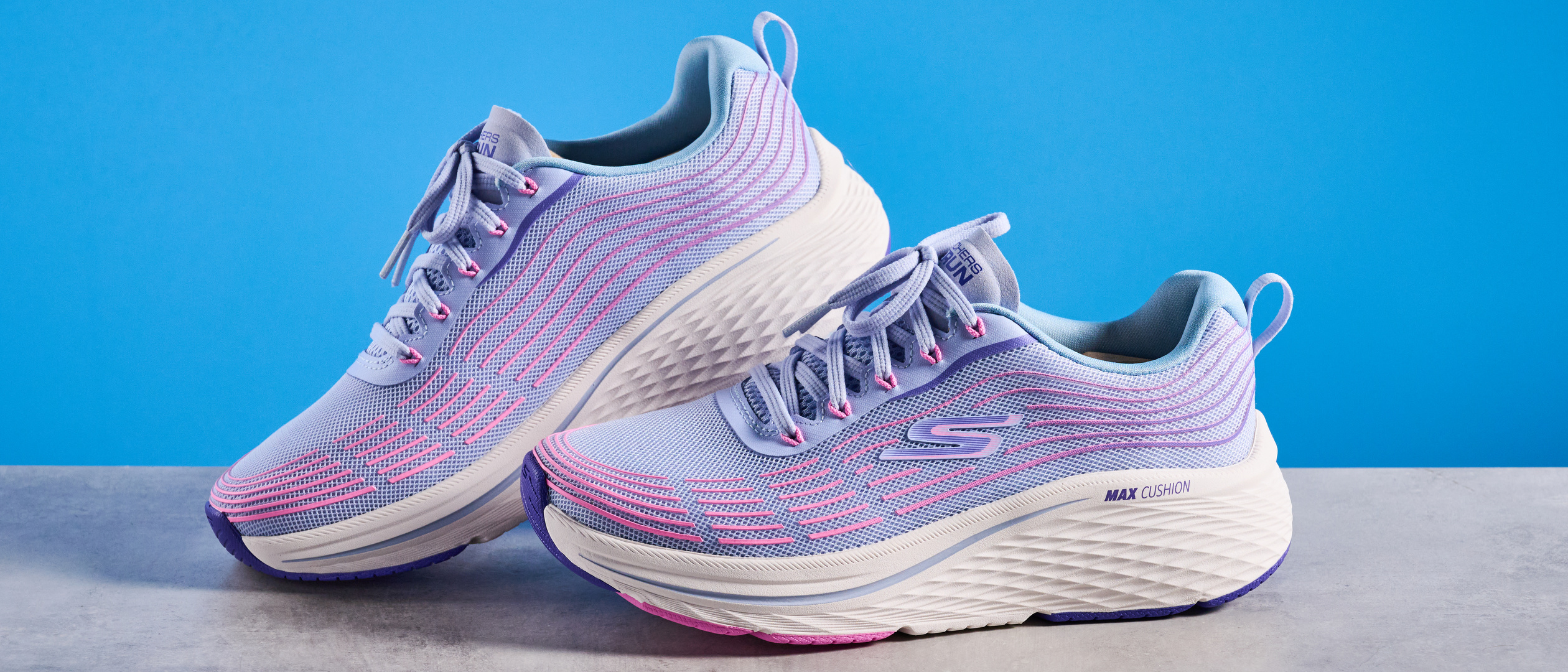 Skechers Max Cushioning Elite 2.0 running shoes photographed in front of a blue background. 