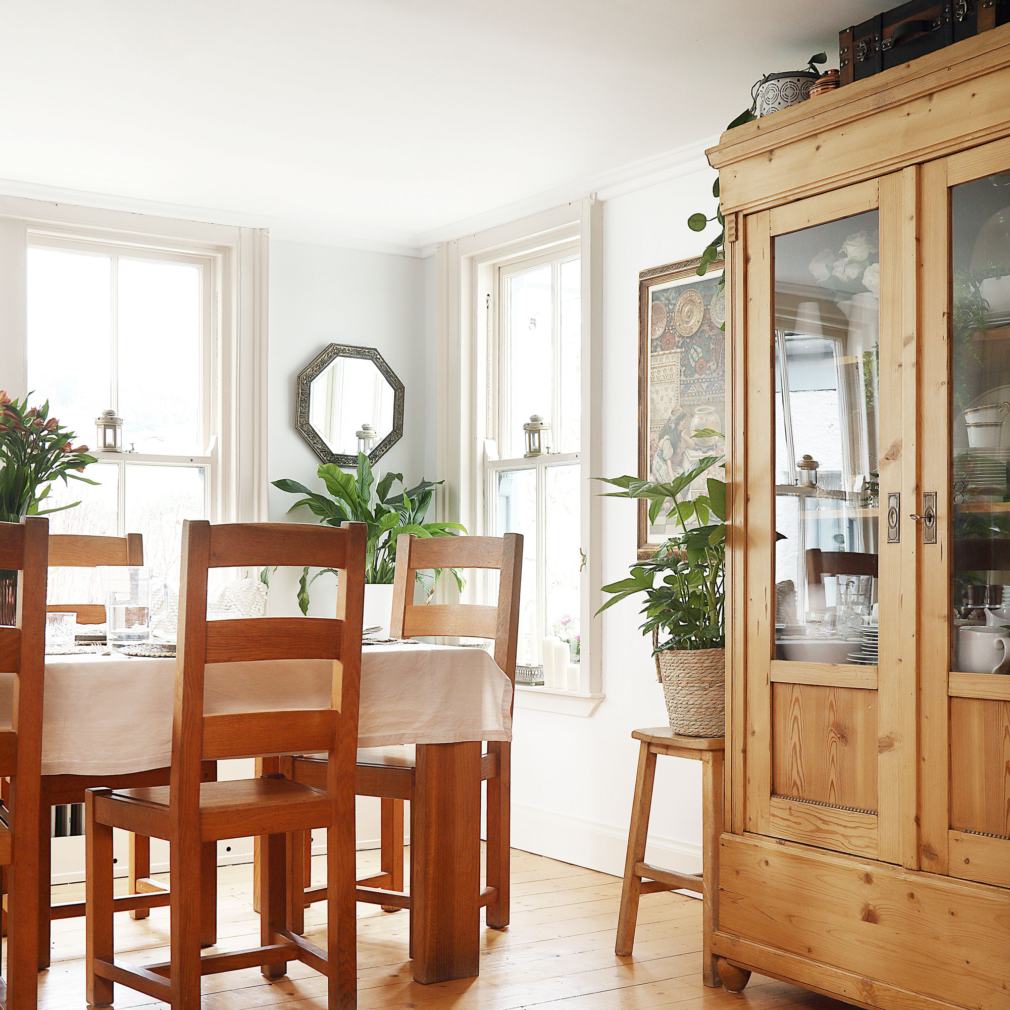 White dining room with wooden armoire with wooden table and chair