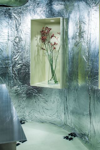 Glass vase by Massproductions in nook with foil clad wall