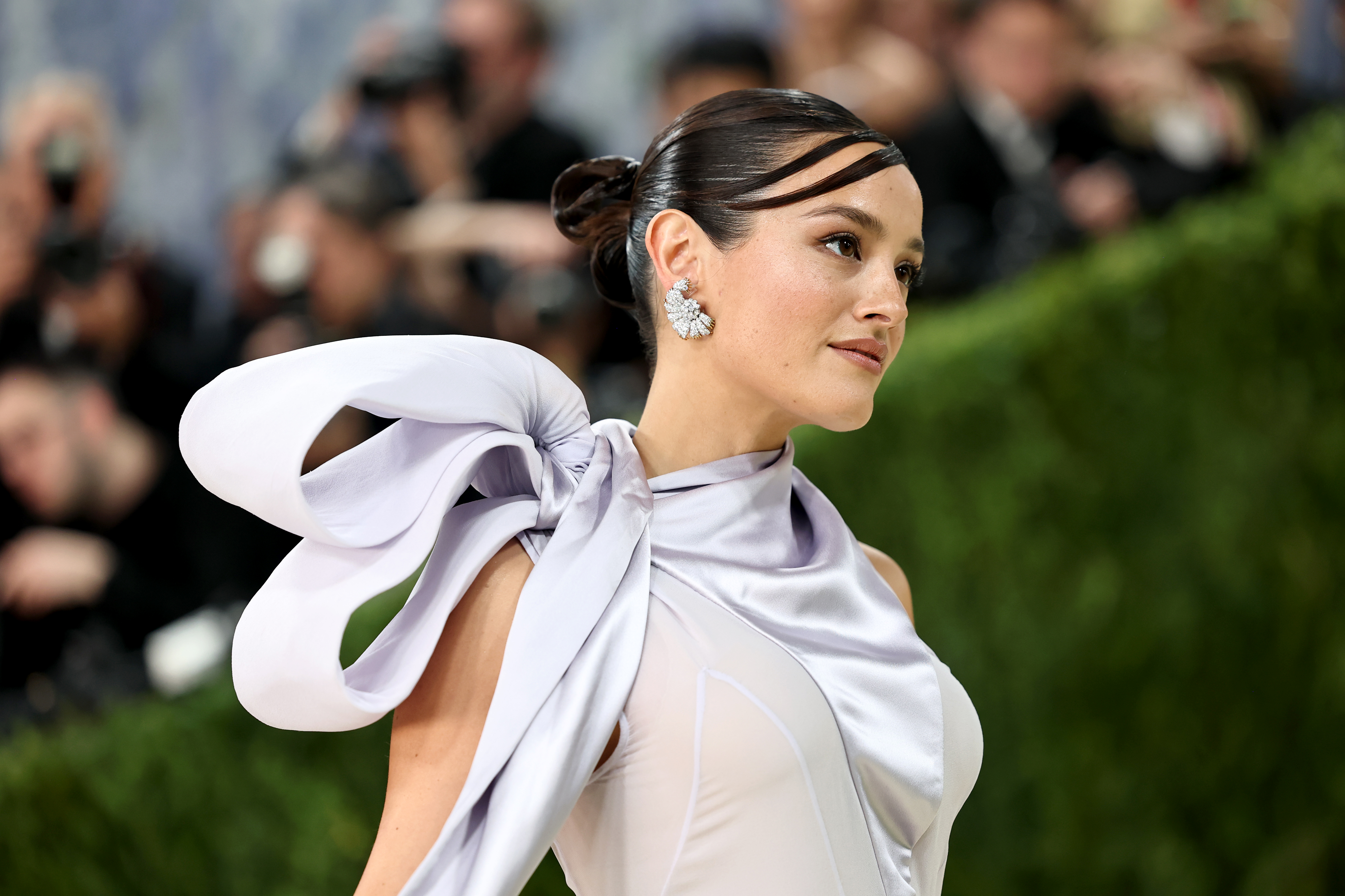 a woman in a lilac dress with a brunette bun