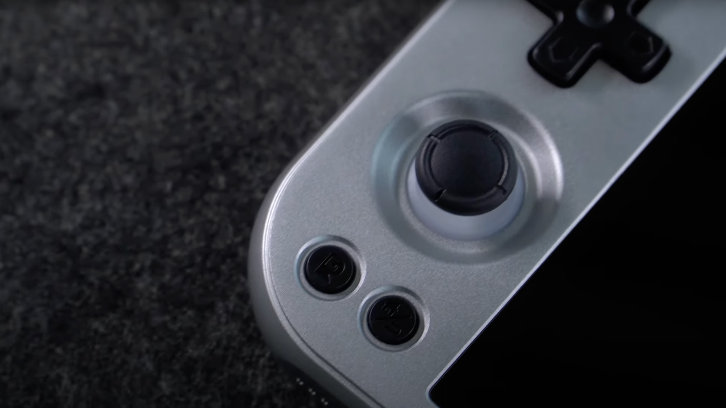 Anbernic RG477M silver/gunmetal close-up on left joystick