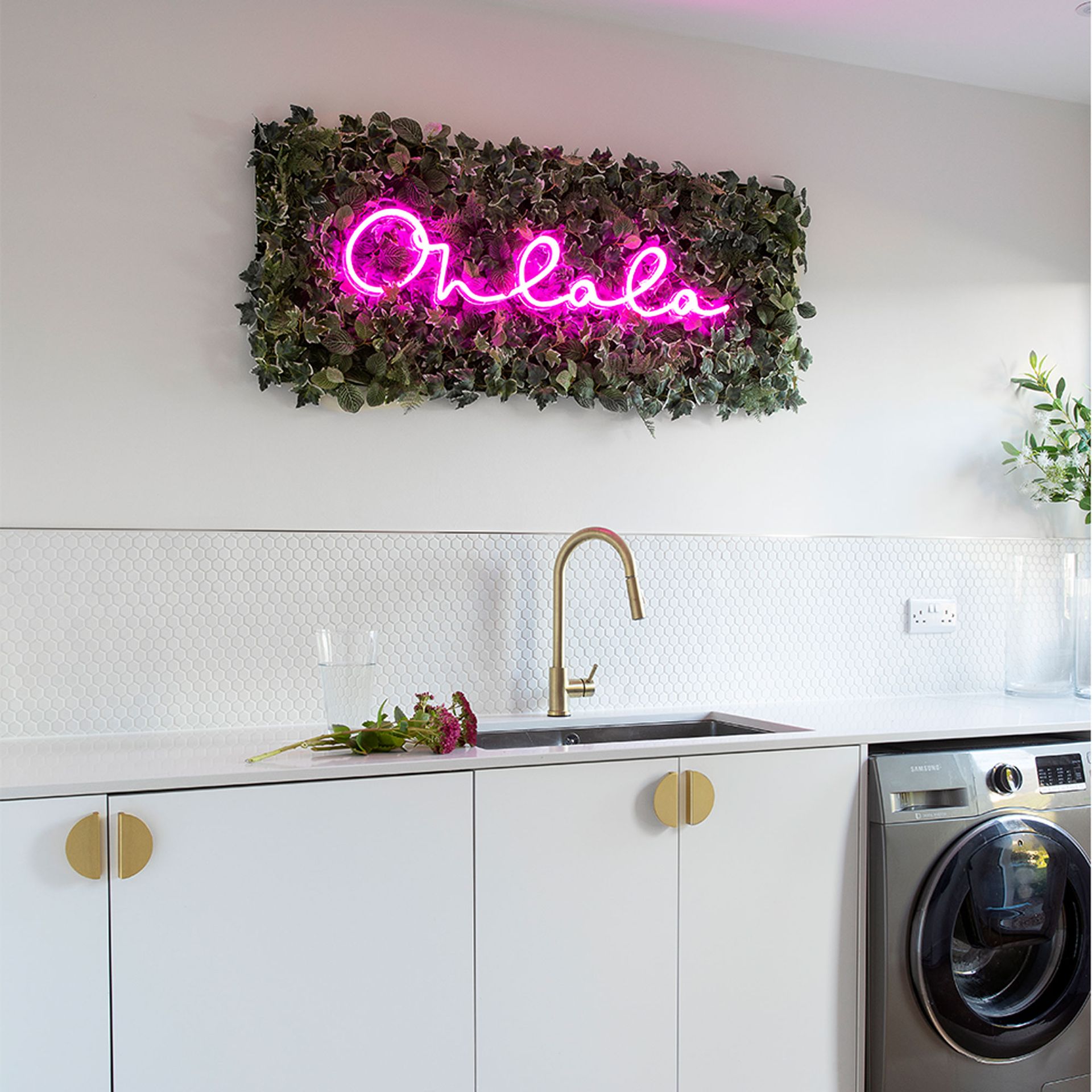 white kitchen with white tiled splashback and neon sign