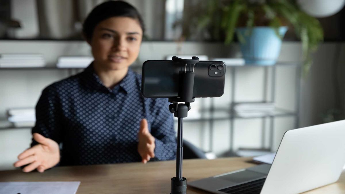 Image showing a woman talking into a smartphone in a tripod