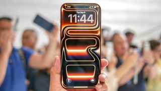 An orange Apple iPhone 17 Pro Max with its default neon wallpaper