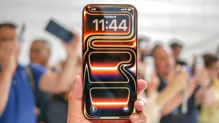 An orange Apple iPhone 17 Pro Max with its default neon wallpaper