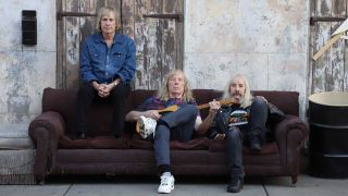 Spinal Tap seated on a sofa in the street 