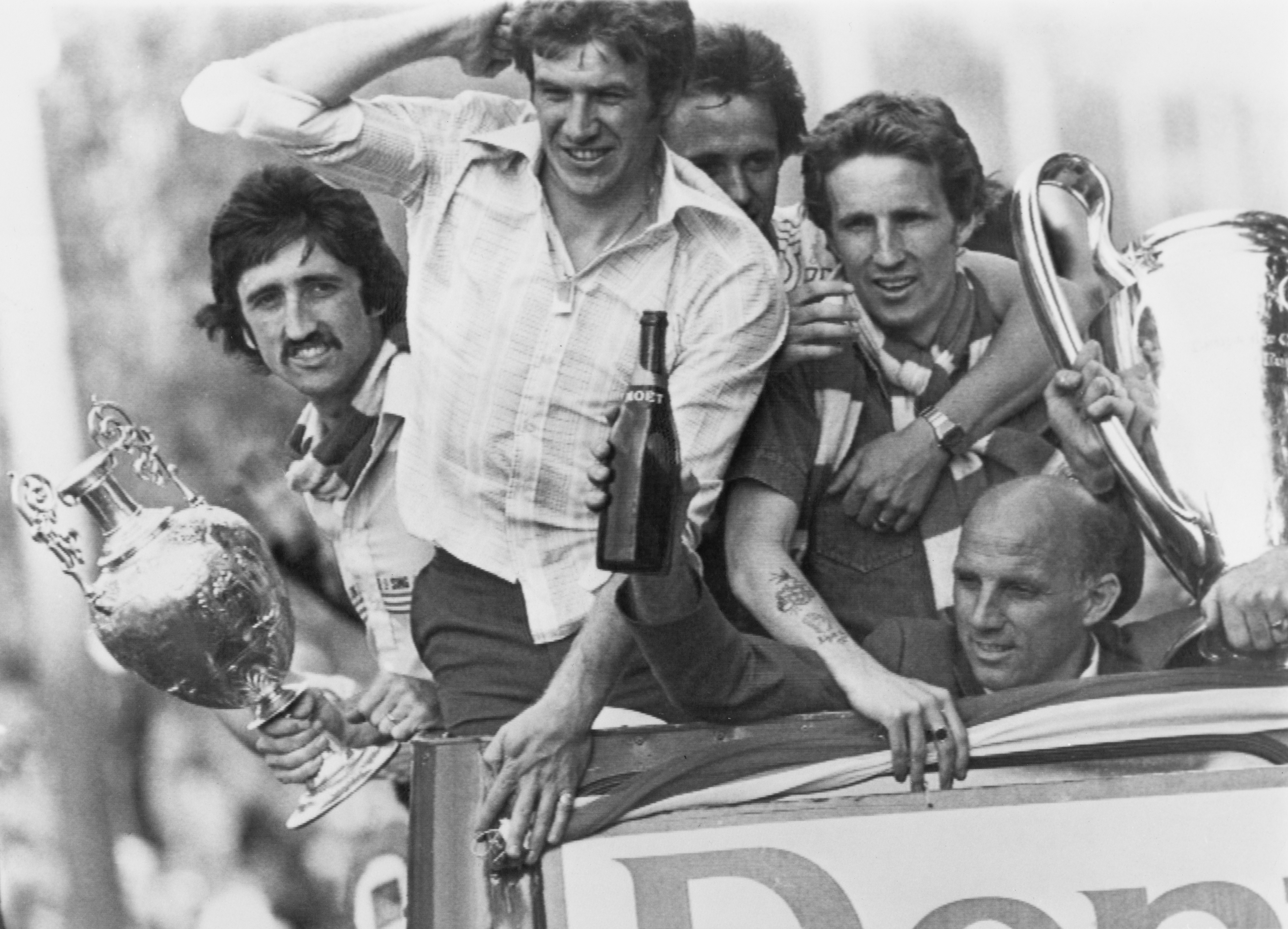 Liverpool players David Johnson, Emlyn Hughes, Phil Neal and Joey Jones celebrate with coach Ronnie Moran on a trophy parade in May 1977 after the Reds' Football League and European Cup wins.