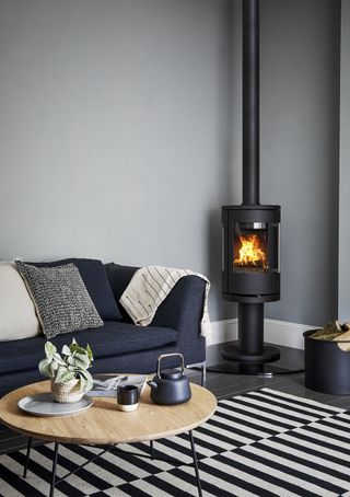 modern log burner in the corner of a living room with sofa