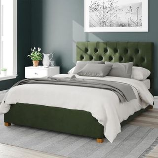 Green bed frame with white bedding on top