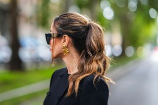 Tamara Kalinic wears sunglasses, golden earrings, outside Dolce & Gabbana, during the Milan Fashion Week - Womenswear Spring/Summer 2024 on September 23, 2023 in Milan, Italy.