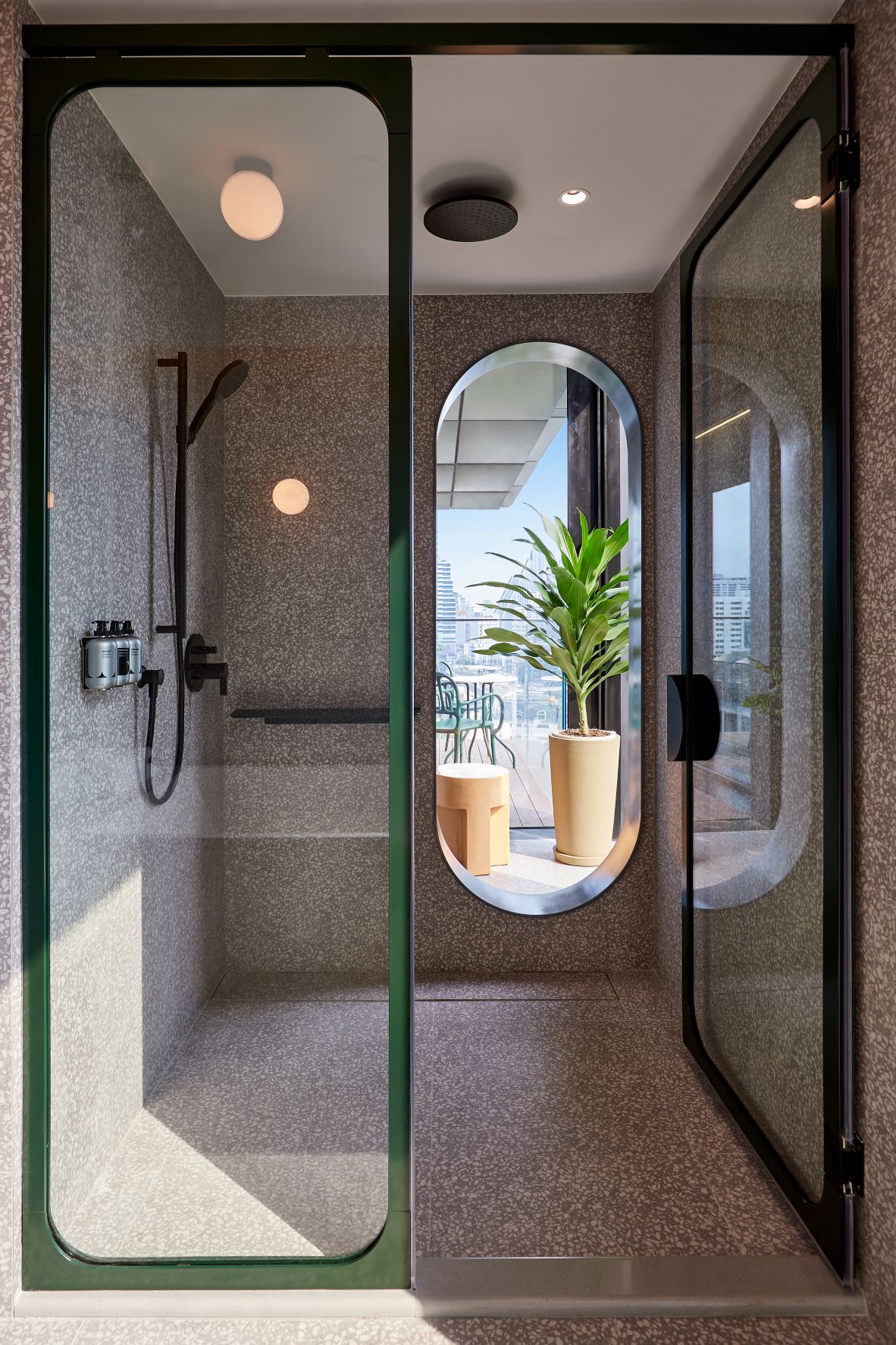 Glass and marble shower with view through to balcony at The Standard Bangkok hotel by Jaime Hayon