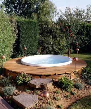 above ground pool with deck and flowerbed