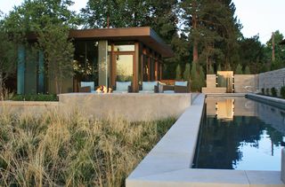 a modern home with landscaping around a pool