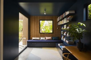 living room with floating green bookshelf and blue sofa