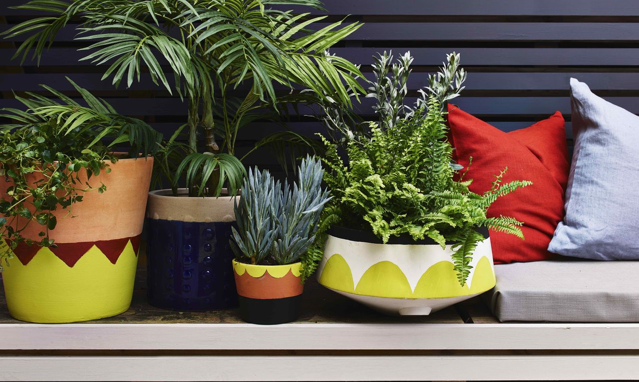 terracotta pots painted in colourful patterns in a modern garden 