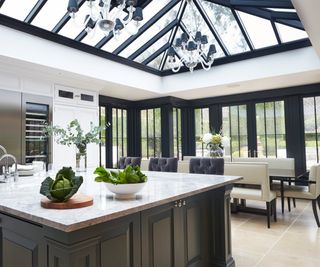 orangery kitchen extension with black framed roof lantern, glazing and large central island with grey units below