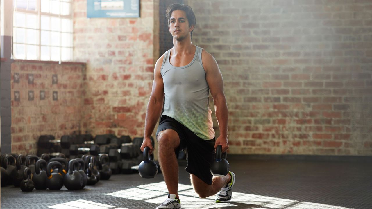 Man performing kettlebell lunges