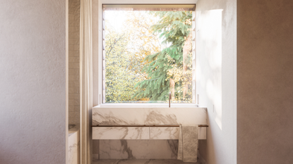 a seamless and sleek bathroom with a marble sink and a big window 