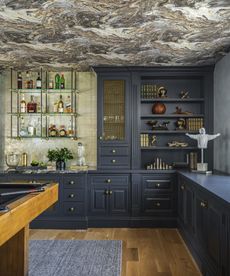 kitchen with blue joinery and patterned ceiling
