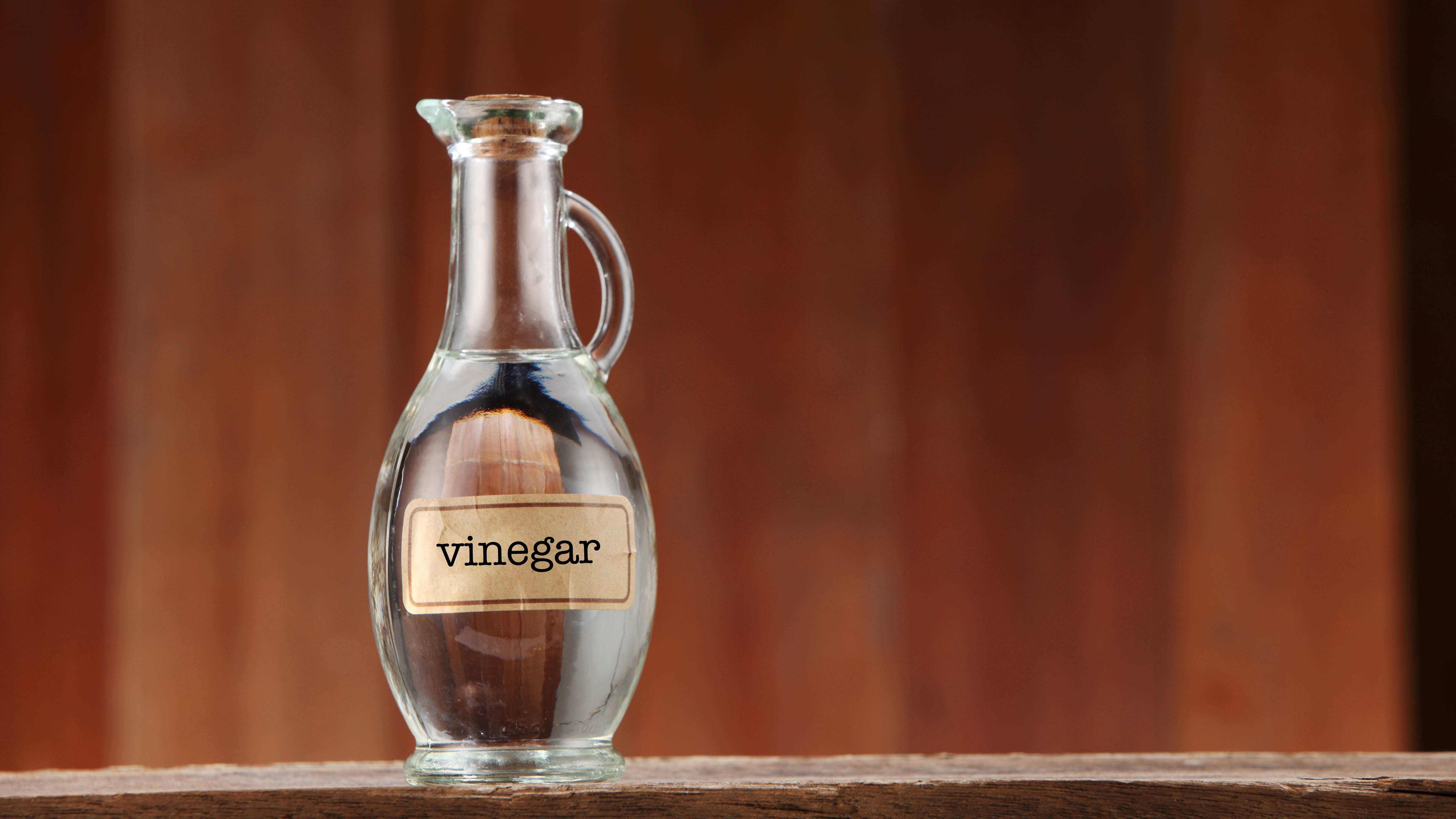 A glass pitcher filled with white vinegar