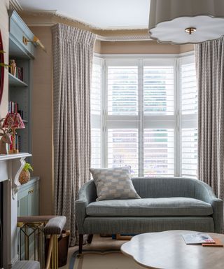 living room with venetian blind and small couch