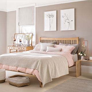 bedroom with pink wall wooden bed and wooden drawer