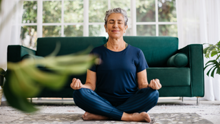 Woman meditating on living room floor