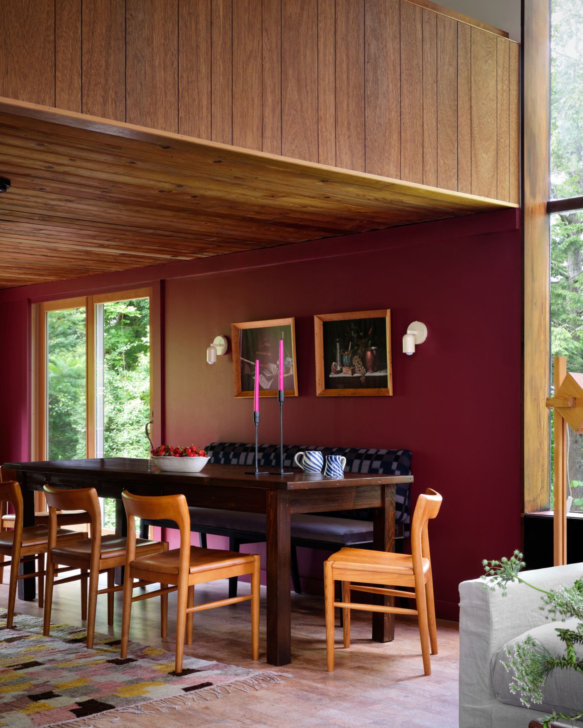 dining room with burgundy paint, timber ceiling, blue banquette seat and timber chairs around dining table