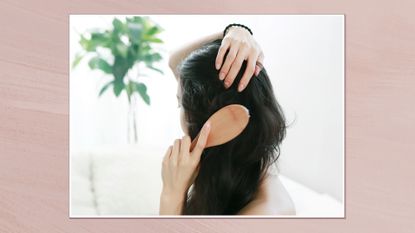 Image showing back view of woman brushing her hair in a white frame on a pink watercolour-style background