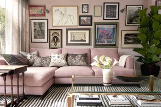 Pink room with comfortable corner sofa and gallery wall of eclectic artwork
