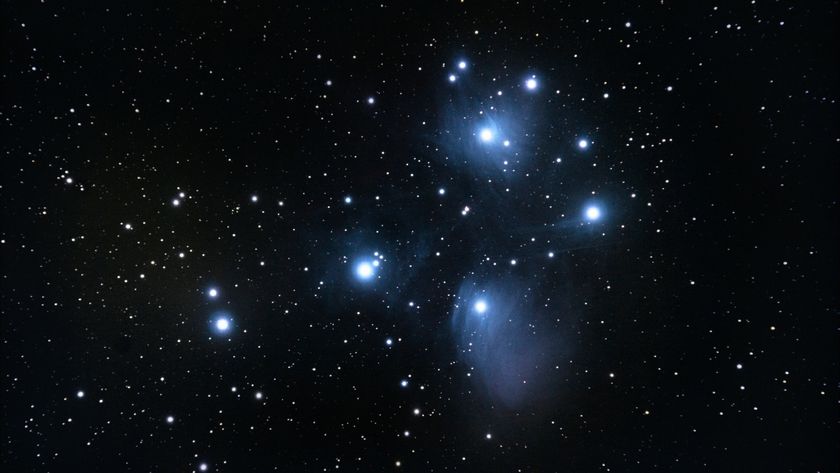 A series of bright blue and white stars shine in a deep space image
