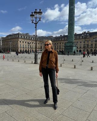 Kristen Nichols in Paris wearing a brown suede bomber jacket and black Zurie Citizens of Humanity jeans.