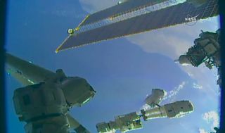 NASA astronaut Ricky Arnold faces the Earth while mounted to the end of the Canadarm2 robotic arm during a spacewalk on June 14, 2018.